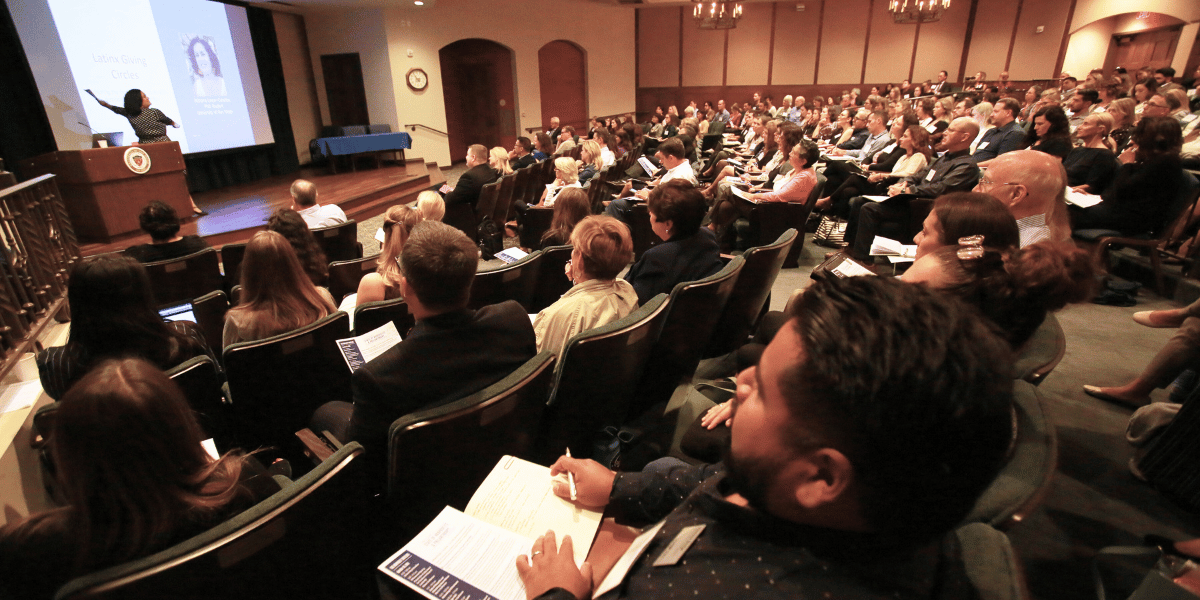 large group of people sitting in an auditorium